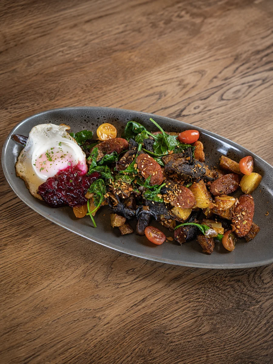 A savoury breakfast plate with eggs, spinach and roasted vegetables at Nourish Cafe